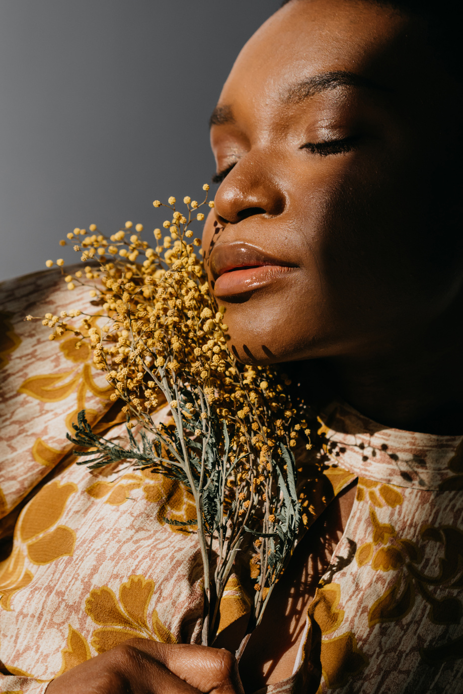 A Woman Holding Yellow Flowers with Her Eyes Closed